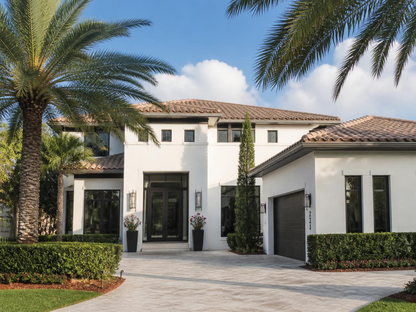 Contractor inspecting impact window installation on the exterior of a Boca Raton coastal home