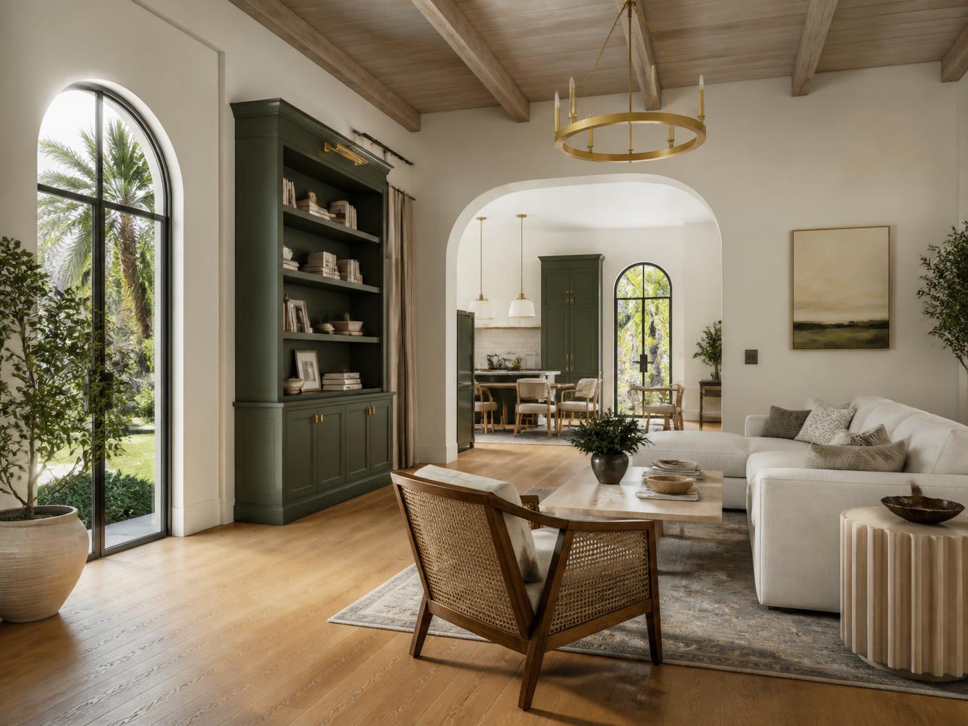 Completed interior renovation in a Boca Raton home with warm ivory plaster walls, deep green built-in millwork, wide-plank oak flooring and brushed brass lighting